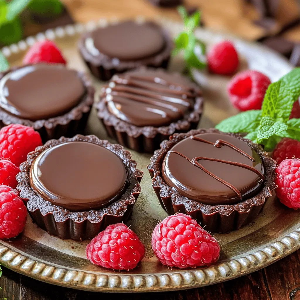 To create the perfect mini chocolate tarts, gather the following ingredients: - 1 ½ cups all-purpose flour - ½ cup unsweetened cocoa powder - ½ cup powdered sugar - ½ cup unsalted butter, cold and diced into small cubes - 1 large egg yolk - 3 tablespoons ice water - 1 cup dark chocolate chips - 1 cup heavy cream - 1 tablespoon vanilla extract - Pinch of salt - Fresh raspberries for garnish - Fresh mint leaves for garnish These simple ingredients come together to form a rich and creamy dessert. Each element plays a key role in the final taste and texture. The all-purpose flour and cocoa powder create a sturdy yet tender crust. The butter ensures a flaky and rich base. The dark chocolate chips and heavy cream form a silky ganache that melts in your mouth. When you gather your ingredients, make sure to use high-quality chocolate. This choice will elevate your tarts to a whole new level. If you want to impress your guests or family, use fresh raspberries and mint leaves for garnish. They add a pop of color and a refreshing taste that balances the richness of the chocolate. If you follow the full recipe, you will find it easy to make these delightful treats at home. Enjoy the process and let your creativity shine! - Preparing the crumb mixture: Start by placing the all-purpose flour, cocoa powder, and powdered sugar in a food processor. Pulse until the mix is fine. This creates a rich base for your tarts. - Forming the dough: Next, add the cold, diced butter to the crumb mix. Pulse again until it looks like coarse crumbs. Then, add the egg yolk and ice water. Pulse until the dough starts to come together. If it feels too dry, add more ice water, a teaspoon at a time. - Chilling in the refrigerator: Take the dough and shape it into a disk. Wrap it tightly in plastic wrap. Chill it in the fridge for at least 30 minutes. This step helps the dough firm up. - Preheating the oven: While the dough chills, preheat your oven to 350°F (175°C). This ensures your tarts bake evenly. - Rolling out and shaping the tart shells: After chilling, roll out the dough on a floured surface to about 1/8 inch thick. Cut out circles that fit your mini tart pan or molds. Press the dough circles into the molds firmly. Use a fork to prick the bottoms, preventing puffing. - Heating the cream: In a medium saucepan, heat the heavy cream over medium heat. Watch for it to simmer, then take it off the heat. - Mixing with chocolate and flavorings: Stir in the dark chocolate chips, vanilla extract, and a pinch of salt. Let it sit for one minute before mixing until smooth. This creates a rich, creamy ganache. - Filling the shells with ganache: Carefully pour the ganache into the cooled tart shells. Fill each one about ¾ full for a perfect balance. - Chilling to set: Place the filled tarts in the fridge for at least one hour. This helps the ganache set nicely, making your tarts firm and ready to serve. Make sure to check the Full Recipe for more details. Enjoy creating these delightful mini chocolate tarts! - Ensuring perfect tart shells: Start with cold butter. This helps create a nice flaky texture. Don’t overwork the dough. Mix just enough to combine. Chill your dough well. This makes it easier to roll out. - Avoiding soggy bottoms: Prick the bottom of each shell with a fork. This allows steam to escape during baking. You can also use pie weights or dried beans for a crispier crust. Bake until the edges are firm but not browned. - Artful plating: Use a nice platter to show off your tarts. Place them in a neat row or a circle. This makes a great visual impact. Drizzle some extra ganache on the plate for flair. - Garnishing suggestions: Fresh raspberries and mint leaves add color and flavor. You can also sprinkle cocoa powder for a touch of elegance. A dusting of powdered sugar can give a sweet look. - What to avoid while making chocolate tarts: Don’t skip chilling the dough. This step is key for a perfect crust. Avoid using warm ganache; it can make the crust soggy. Lastly, don’t rush the setting time. Chilling is vital for the tarts to hold their shape. These tips ensure you create the perfect mini chocolate tarts. For more details, check the Full Recipe. Enjoy your baking! {{image_4}} You can add fun twists to your mini chocolate tarts. Here are a couple of great ideas: - Fruit-infused ganache: You can mix in pureed fruits. Raspberries, oranges, or even espresso create exciting flavors. Start by heating your cream with the fruit puree, then add chocolate chips. The result is a luscious and fruity filling. - Nut-based variations: Swap in nut butters or chopped nuts for a rich taste. Almond or hazelnut spreads add creamy texture. You can also fold in crushed nuts like pecans or walnuts. This gives your tarts a delightful crunch. Toppings can make your mini chocolate tarts even more special. Here are some options: - Alternative toppings and textures: Try whipped cream, chocolate shavings, or crushed cookies. Each adds a unique layer of flavor and texture. Consider sprinkling sea salt on top for a sweet-salty combo. - Seasonal flavor combinations: Use seasonal fruits to keep it fresh. Top with strawberries in spring, peaches in summer, or pumpkin in fall. These add color and brightness to your tarts. For the full recipe, check the detailed steps to create these delightful treats! To keep your mini chocolate tarts fresh, store them in the refrigerator. First, place them in an airtight container. This will stop them from drying out or picking up other smells. You can stack them carefully, but use parchment paper between layers if needed. For longer storage, you can freeze the tarts. Wrap each tart tightly in plastic wrap. Then, place them in a freezer-safe bag or container. This helps prevent freezer burn. When you’re ready to enjoy them, thaw them in the fridge overnight. Mini chocolate tarts can last about 3-4 days in the fridge. If you freeze them, they can stay good for about 2-3 months. Just remember to check for any changes in texture or taste before serving. Enjoy your delicious dessert with confidence! For the complete process, refer to the Full Recipe. You start by making the tart crust. Mix all-purpose flour, cocoa powder, and powdered sugar. Then, add cold diced butter, pulsing until it’s crumbly. Next, add an egg yolk and ice water. Pulse again until the dough comes together. Chill this dough for 30 minutes. After chilling, roll it out, cut rounds, and press them into tart molds. Bake until firm, then cool completely. For the ganache, heat heavy cream until it simmers. Stir in dark chocolate chips and vanilla until smooth. Fill the cooled tart shells and chill until set. For the full recipe, click [here](#Full Recipe). Yes, you can! Dark chocolate works best for a rich flavor, but you can try milk or white chocolate. Just remember, milk chocolate will make the ganache sweeter. Adjust the sugar in your crust if needed. Each type of chocolate gives a unique taste and texture to your tarts. Fresh raspberries and mint leaves make great garnishes. They add color and flavor. You can also drizzle melted chocolate on top. For a twist, try adding crushed nuts or edible flowers. These little touches make your tarts look fancy and inviting! To keep your tarts balanced, use dark chocolate for the ganache. It has less sugar and a deeper flavor. You can also reduce the powdered sugar in the crust. Taste the ganache before filling the tarts. Adjust the sweetness to your liking by adding a pinch of salt or a splash of espresso. Yes! You can replace all-purpose flour with a gluten-free flour blend. Almond flour works well too. Just make sure to check that your cocoa powder and chocolate are gluten-free. These swaps keep the crust delicious while making it safe for those with gluten sensitivities. You learned how to make mini chocolate tarts from scratch. We covered every step, from creating the tart crust to making rich ganache. You discovered tips for perfect results and how to present your tarts beautifully. You can try different fillings and toppings to mix things up. Remember to store your tarts right to keep them fresh. These sweet treats are perfect for any occasion. Enjoy making and sharing them!