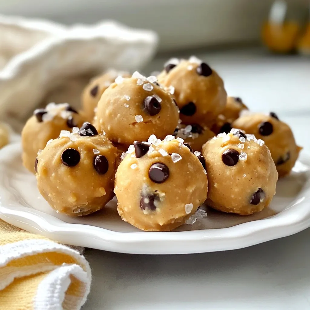 - 1 cup almond flour - ½ cup rolled oats - ½ cup creamy peanut butter or almond butter - 1/3 cup maple syrup or honey - 1 teaspoon vanilla extract - ½ cup mini chocolate chips - A pinch of sea salt - 2 tablespoons cocoa powder (optional) When I make these No-Bake Baileys Cookie Dough Bites, I start with simple and healthy ingredients. Almond flour gives a nice nutty taste, while rolled oats add texture. Peanut butter adds creaminess, and maple syrup sweetens the mix well. The mini chocolate chips bring joy to every bite, and the pinch of sea salt balances the sweetness. If you love chocolate, the cocoa powder is a fun touch! If you don’t have almond flour, you can use oat flour or regular flour. Rolled oats can be swapped with quick oats or ground oats if needed. For nut butter, try sunflower seed butter if you need a nut-free option. As for sweeteners, agave or stevia works just as well if you want a different flavor or lower sugar. You can get creative with the mix-ins! Use dark or white chocolate chips for a twist. Chopped nuts or seeds add crunch. Dried fruits like cranberries or raisins can bring extra sweetness and chewiness to the bites. Feel free to experiment! Each mix-in adds a fun surprise in every bite. {{ingredient_image_2}} First, gather your dry ingredients in a large bowl. Combine 1 cup of almond flour, ½ cup of rolled oats, and a pinch of sea salt. If you want a chocolate version, sift in 2 tablespoons of cocoa powder. Mixing these gives your bites a great base. Now, let’s move on to the wet ingredients. In another bowl, blend ½ cup of creamy peanut butter, 1/3 cup of maple syrup, and 1 teaspoon of vanilla extract. Stir until smooth. This blend brings a lovely flavor to the bites. Pour your wet mixture into the dry ingredients. Use a spatula to mix well. Ensure there are no dry spots left. Next, gently fold in ½ cup of mini chocolate chips. This step makes every bite deliciously sweet. With slightly damp hands, roll small portions of the mixture into balls. Aim for about 1 inch in diameter. Place them on a parchment-lined baking sheet. Once you form all the bites, chill them in the fridge for about 30 minutes. Chilling helps them set and makes them easier to enjoy. Using the right almond flour is key. Choose a finely ground almond flour for smooth bites. This helps the dough mix well and stay soft. If you use a coarser flour, the bites may be gritty. For consistency checks, look for a dough that sticks together. It should feel slightly moist, but not too sticky. If the dough falls apart, add a bit more nut butter or syrup. Mix until all ingredients blend nicely. To prevent sticking, dampen your hands slightly. This simple trick helps form the balls easily. If your hands are too dry, the dough may cling to your fingers. Before chilling, store the formed bites on parchment paper. This keeps them from sticking together. It also makes for easy removal when you are ready to enjoy. When plating, arrange the bites on a colorful plate. Add a sprinkle of extra chocolate chips for flair. You could also include fresh fruit, like strawberries or blueberries, for a nice touch. For beverages, pair these bites with coffee or a glass of milk. A sweet dessert wine could also enhance the experience. Experiment with what you like best! Pro Tips Use Chilled Ingredients: Chilling your peanut butter or almond butter before mixing helps achieve a smoother consistency, making it easier to combine with other ingredients. Experiment with Mix-ins: Feel free to add nuts, seeds, or dried fruit to customize your cookie dough bites and enhance their texture and flavor. Adjust Sweetness: Taste the mixture before forming the bites and adjust the sweetness by adding more maple syrup or honey if needed. Storage Tips: For longer freshness, consider freezing the bites in an airtight container. They make for a quick and healthy snack straight from the freezer! {{image_4}} You can easily make a chocolate version of your no-bake cookie dough bites. To do this, add 2 tablespoons of cocoa powder during the dry ingredient step. This will give your bites a rich, chocolate flavor. For a fun twist, use chocolate chips instead of mini chocolate chips. Dark, semisweet, or even white chocolate chips can add a nice touch. If you want to make these bites vegan, there are simple swaps. Use maple syrup instead of honey. Choose almond butter or another nut butter that is plant-based. You can also use coconut flour in place of almond flour. This will keep the bites tasty and vegan-friendly. Want to spice things up? You can add a pinch of cinnamon or nutmeg to your mixture. These spices give a warm flavor that pairs well with the sweetness. Also, try adding a splash of almond or hazelnut extract. Just a little bit can create a whole new flavor profile for your bites. Experiment and find what you love! To keep your no-bake Baileys cookie dough bites fresh, use an airtight container. This helps prevent them from drying out or absorbing other smells in the fridge. Place a piece of parchment paper between layers to avoid sticking. Store them in the refrigerator for the best taste and texture. These cookie dough bites last up to a week in the fridge. After a few days, check for signs of spoilage. Look for any off smells or a change in texture. If they feel sticky or hard, it’s best to toss them. You can freeze the cookie dough bites for future treats. Here’s how: - Arrange the bites on a baking sheet and freeze them for about an hour. - Once firm, transfer them to a freezer-safe bag or container. - Label the bag with the date. To thaw, simply take out the desired number of bites and let them sit at room temperature for about 15-20 minutes before enjoying. This way, you can always have a sweet treat ready to go! Yes, you can make these bites gluten-free. Use oat flour instead of almond flour. Check that your oats are labeled gluten-free. This way, you can enjoy a safe and tasty treat. To check if your bites are ready, feel for firmness. They should not be too soft. You can also taste one to see if the flavor is to your liking. If they hold their shape and taste great, they are ready. Absolutely! You can explore many flavors of Baileys. Consider using vanilla, espresso, or even salted caramel. Each flavor will give your cookie dough bites a fun twist. Experimenting with flavors keeps things exciting! You learned how to make tasty no-bake cookie dough bites. We went through the ingredients, mixing, and tips for perfect bites. You can try different flavors and mix-ins for fun twists. Store them well so they stay fresh. My final thought? These bites make snack time memorable and easy. Enjoy creating, sharing, and tasting your delicious treats!